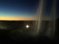 滝の裏側から見た景色。遠くに見える夕焼けが美しい
