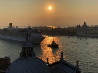 夕闇のベネチア運河を出航するクルーズ船