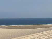 砂漠が海に流れ込む幻想的な景色(コントラスト)、小高い砂丘群が美しい