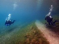 湖の中に伸びる遊歩道とダイバー